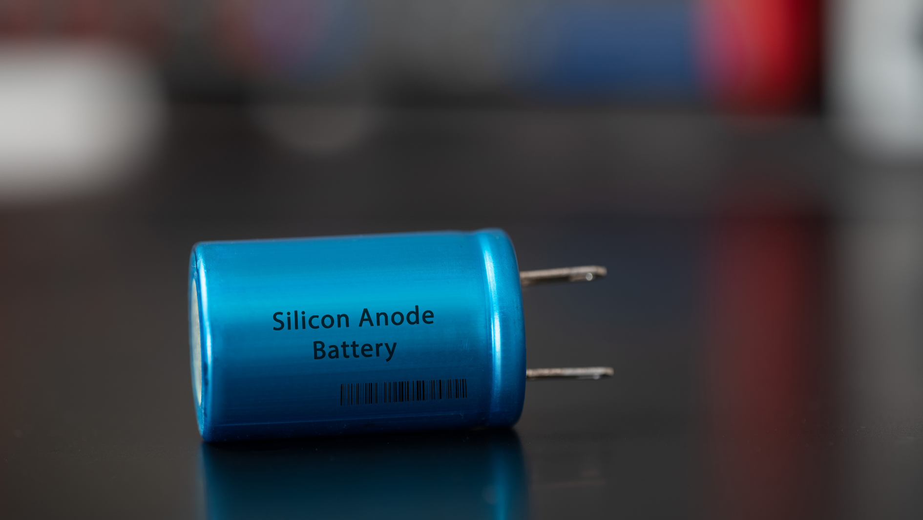 Blue silicon anode battery in front of dark background.