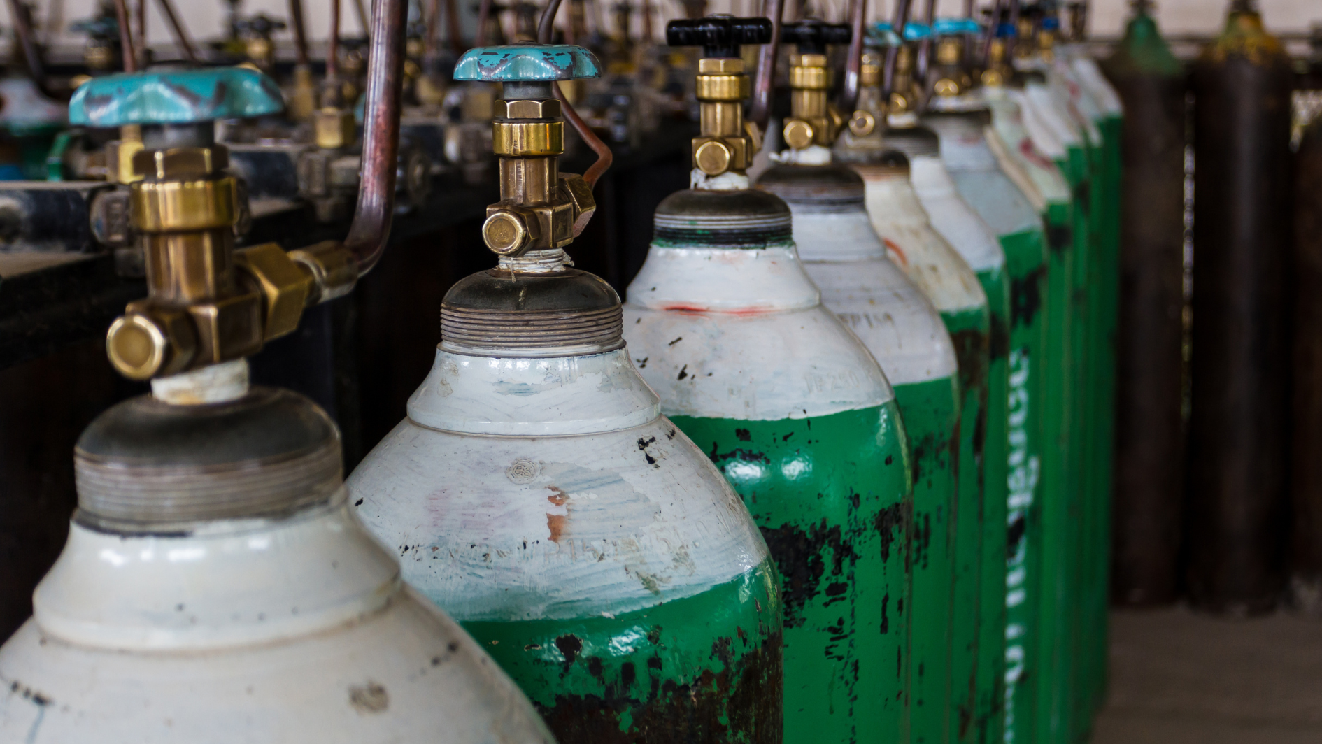 The photo shows slim oxygen tanks lined up in a row